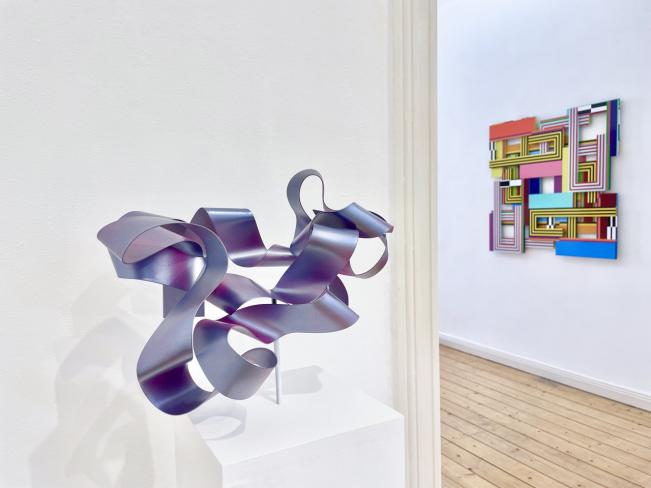 Hans Schüle, aus der Werkgruppe "Loops", 2023, Lack auf Stahl, 23 x 34 x 29 cm, Ausstellungsansicht mit Dieter Balzer